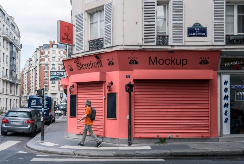 Street-level storefront mockup in urban setting with shutters down, clear signage space, and a pedestrian walking by, ideal for display designs.